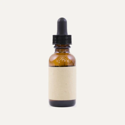 An amber glass dropper bottle with a printed label applied