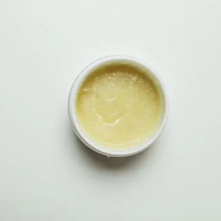 A white double-wall cosmetic jar with a printed label applied